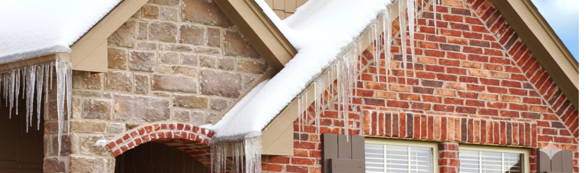 Formation de glace et de glaçons en bordure de toit causée par l’accumulation de neige, un signe qu’un déneigement de toiture devient nécessaire.